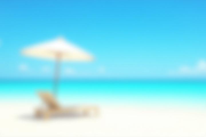 Lugn vit sandstrand med parasoll under solig himmel